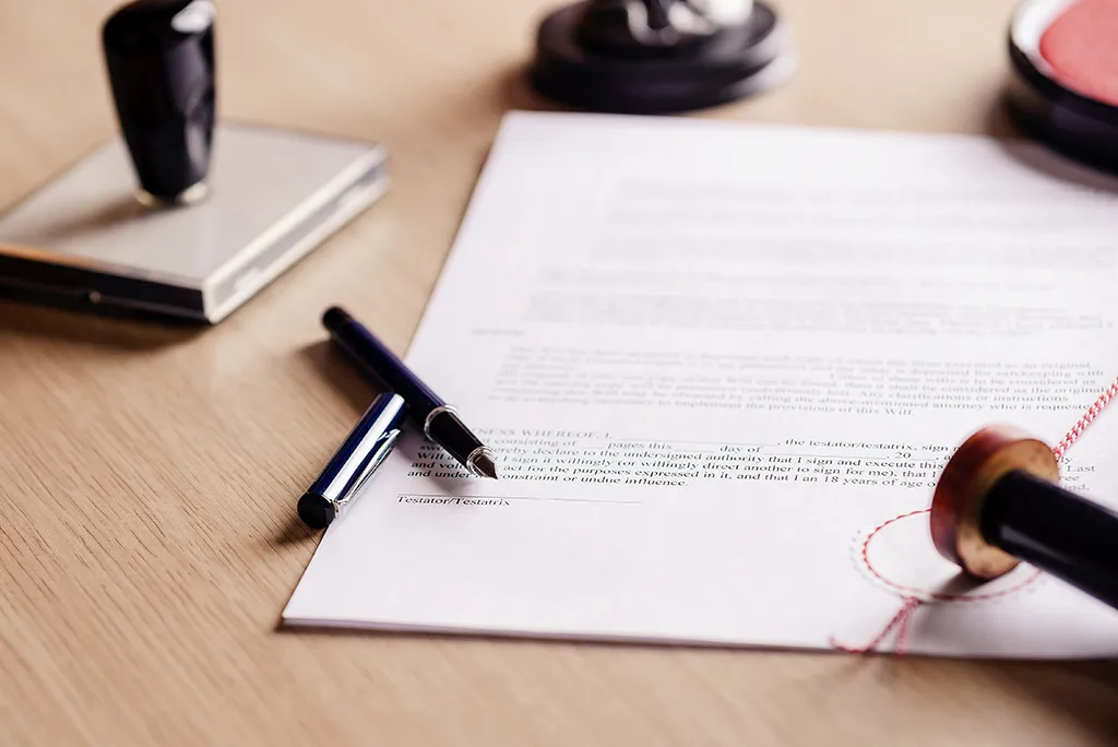 A pen, ink pad and wax seal stamp on a document awaiting an Apostille